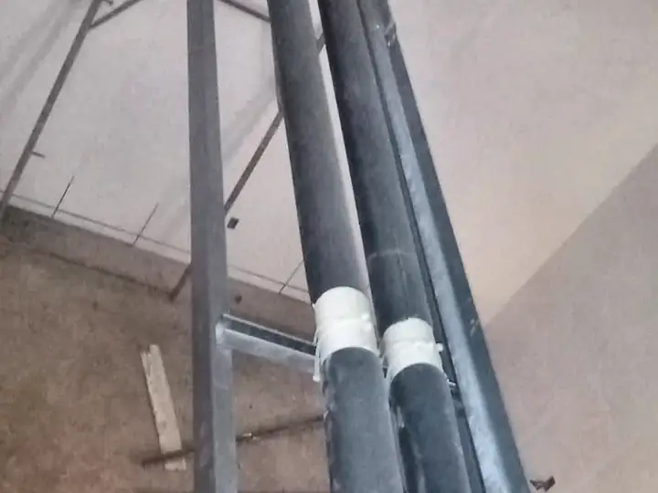 Tubulações isoladas presas em estrutura metálica vertical