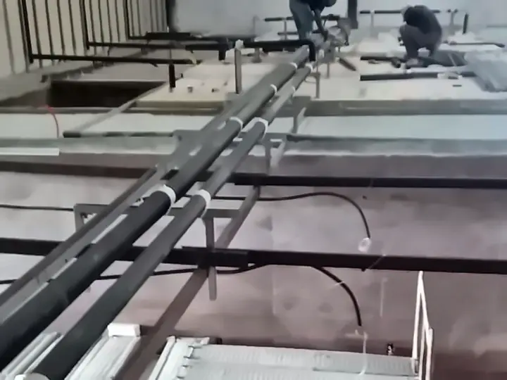 Técnicos trabalhando na montagem da rede de tubulação sobre câmaras frias