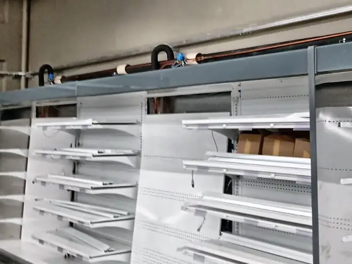 Expositor refrigerado aberto de supermercado com as linhas de refrigeração instaladas acima