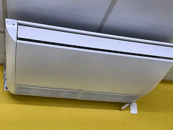 Ar-condicionado piso-teto instalado junto ao forro em parede amarela