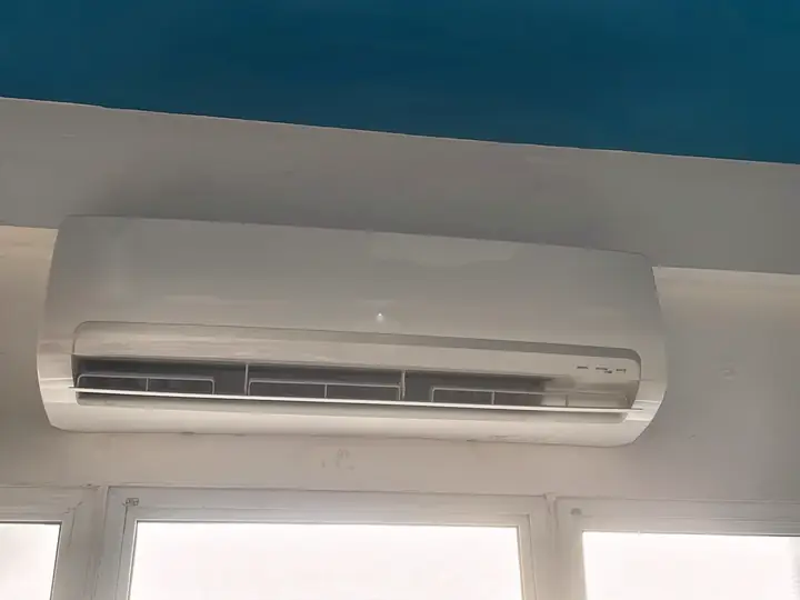Ar-condicionado split instalado acima de uma janela, junto à viga