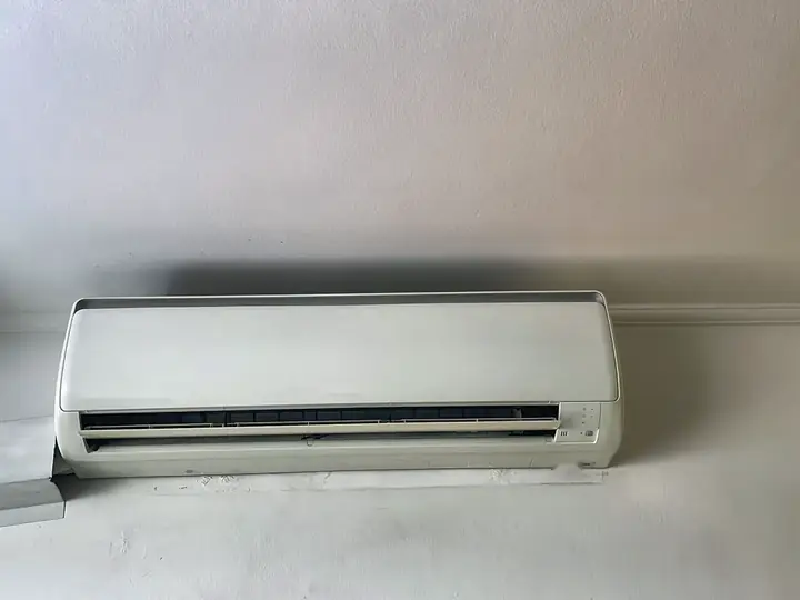 Ar-condicionado split em parede branca após a manutenção