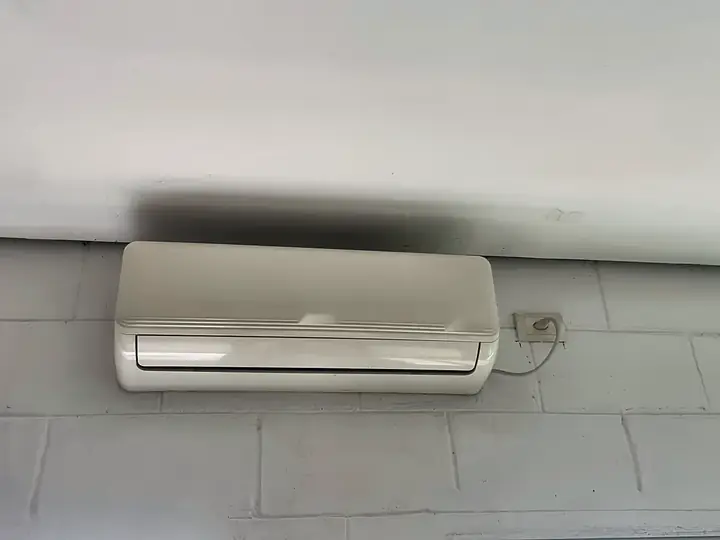 Ar-condicionado split instalado em parede de blocos pintados, com tomada exclusiva