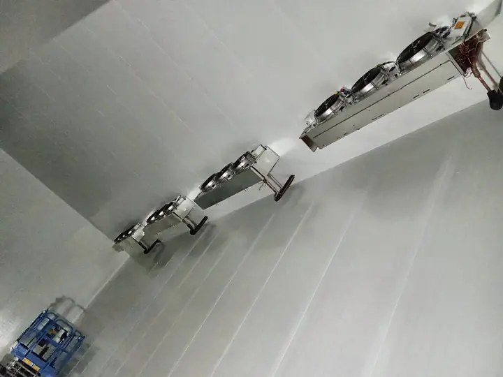 Evaporadores com três ventiladores instalados no teto de câmara fria de grande porte