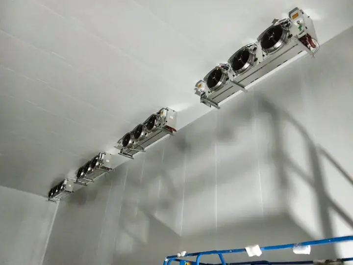 Linha de evaporadores instalados em sequência no teto de uma câmara fria