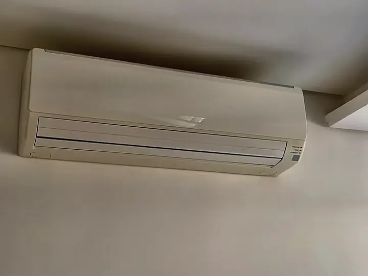 Ar-condicionado split instalado junto ao teto, revisado